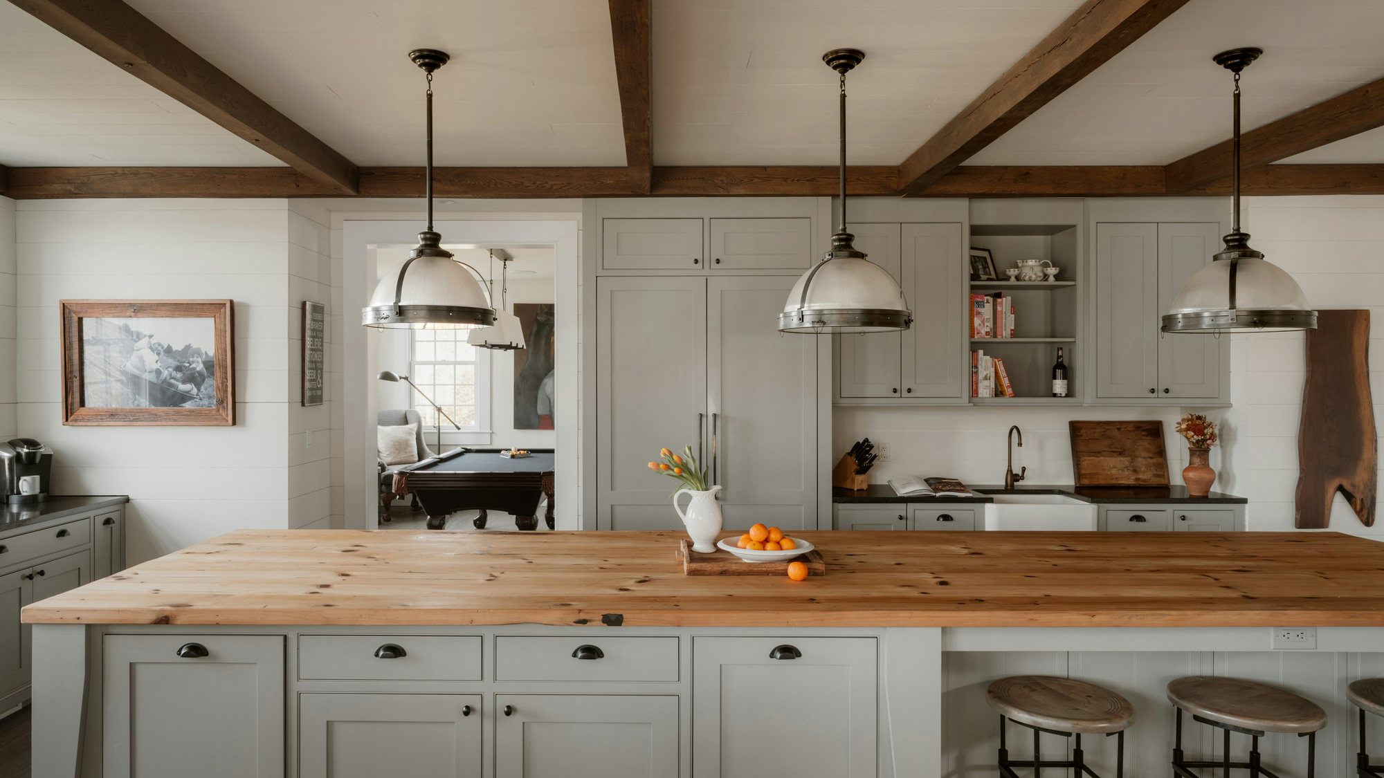 A farmhouse kitchen with a long wood island