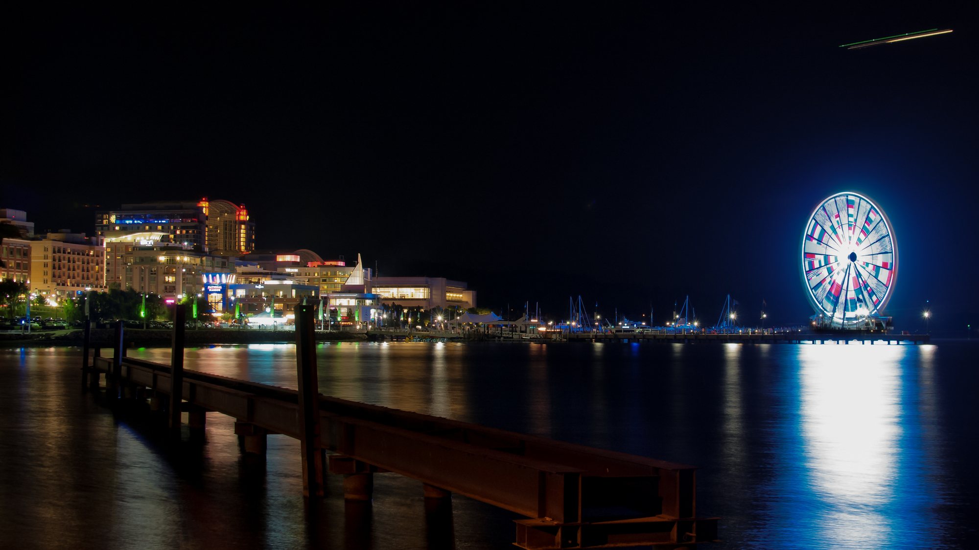 National Harbor at night, with the waterfront lights reflected in the Potomac