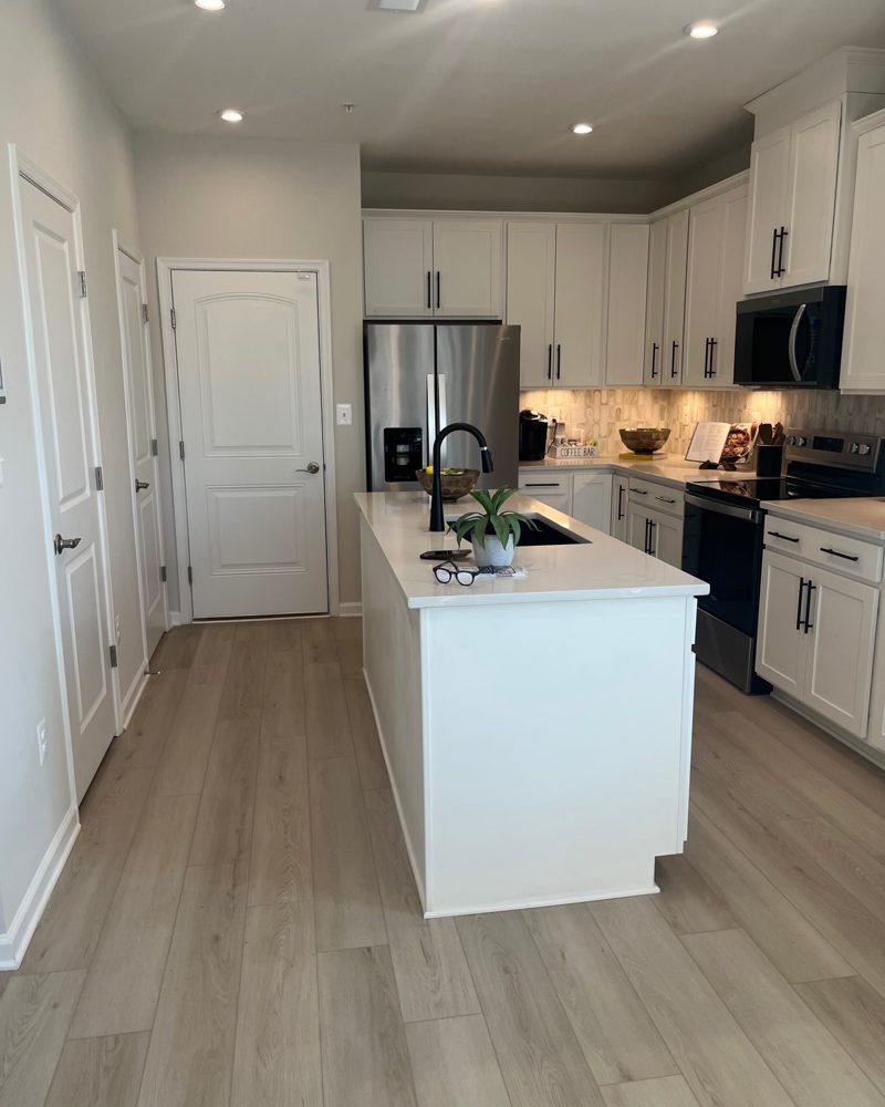 A white kitchen with an island in a 55 and older community home