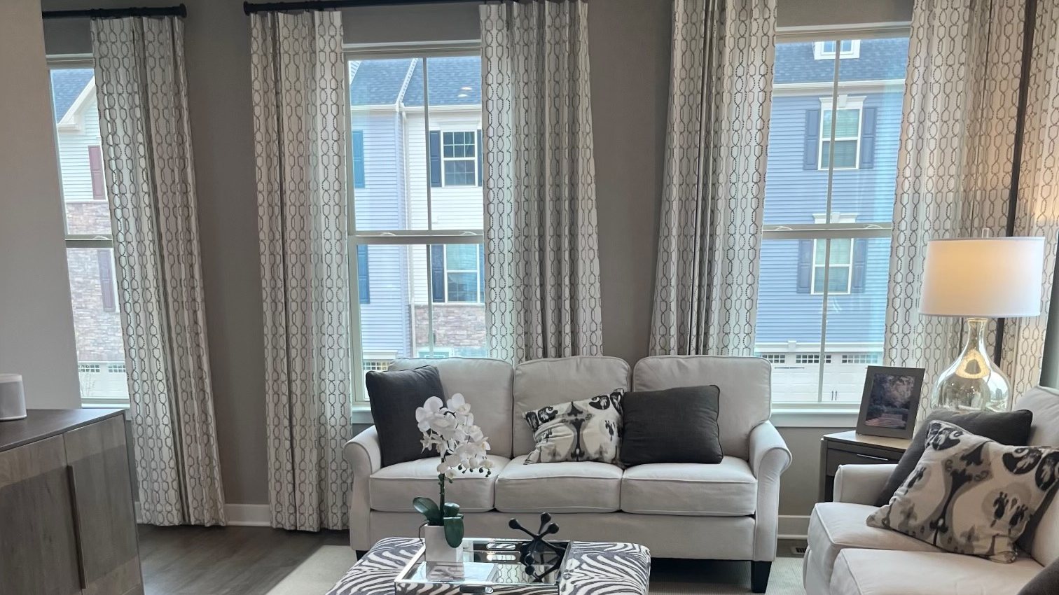 The living room of a new townhome model with tall windows
