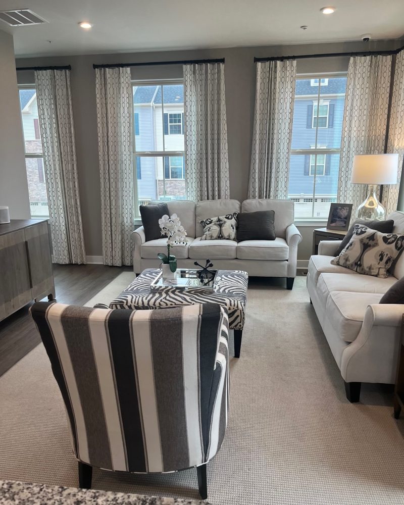 A townhome model living room with three tall windows