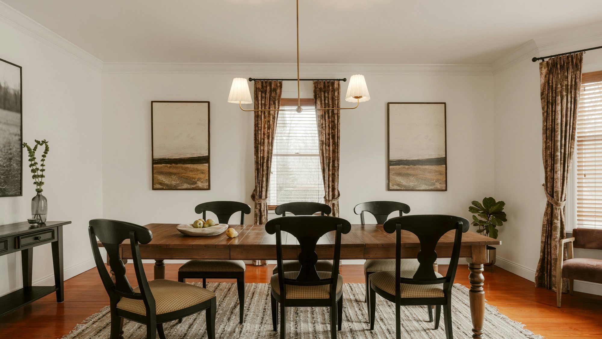 A dining room with a wood table and black chairs