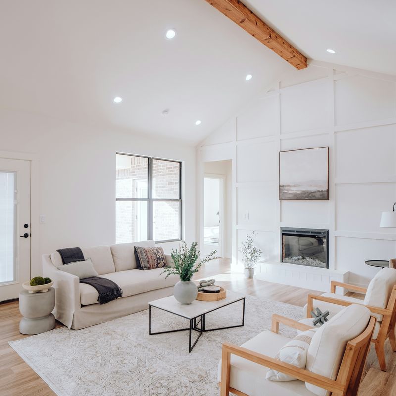 A bright living room with a white sofa and a fireplace